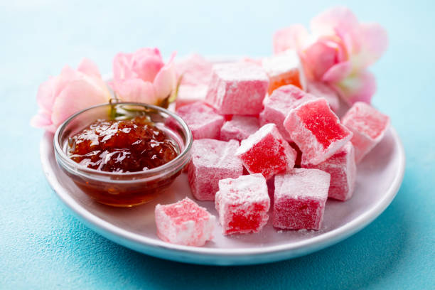 istock Turkish delight, rose flavour in a white plate. Blue background. Close up. 1214957960