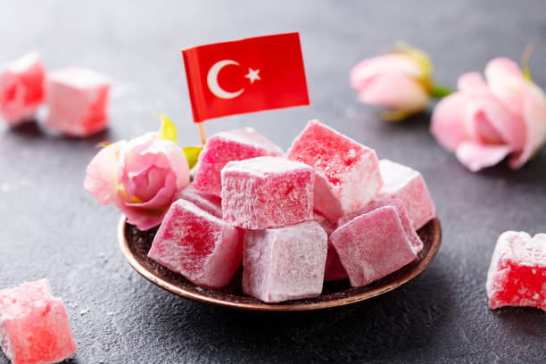 istock Turkish delight, rose flavour in a copper plate with Turkish flag. Grey background. Close up. 1214958266