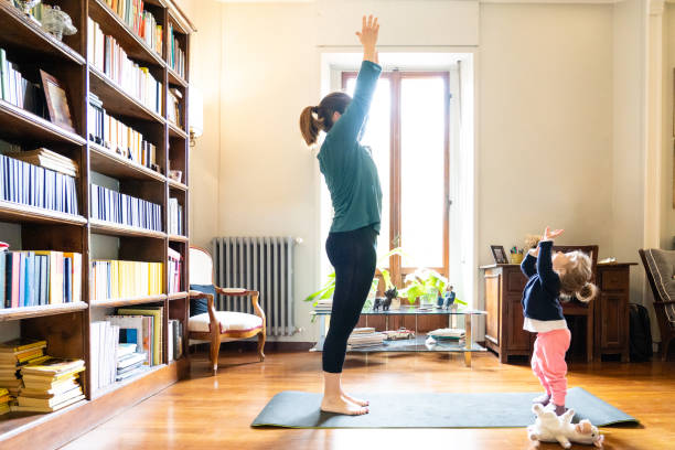 istock mother and daughter doing yoga together 1214959042