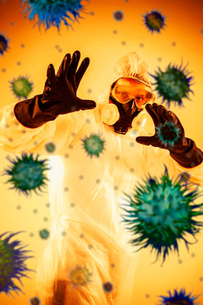 防護服を着た男と彼の周りを飛んでいるウイルス。 - toxic waste radiation protection suit chemical protective suit ストックフォトと画像