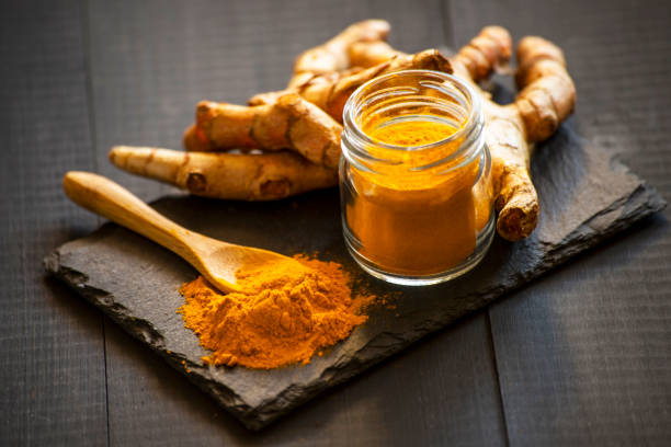 istock Turmeric powder with fresh turmeric root 1214961386