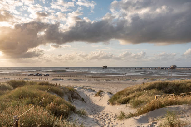 Dune landscape with beach, stilt houses in the background, St Peter-Ording in North Friesland in Germany