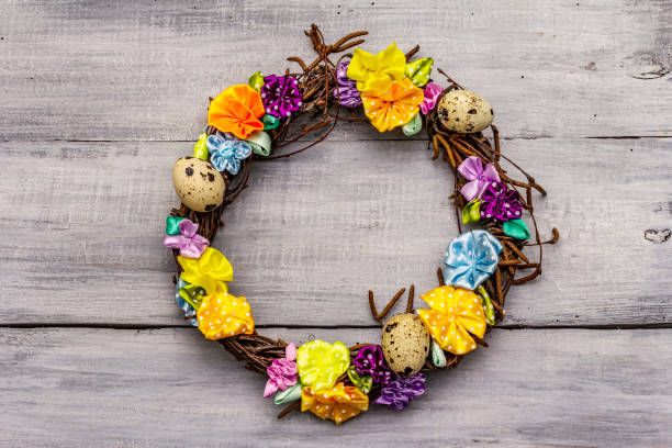istock Hand crafted Easter wicker wreath with quail eggs and handmade flowers. Birch branches, polka dot satin ribbon. Stay at home concept 1214965148