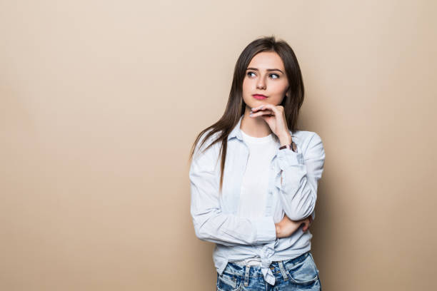 istock Young woman thinking isolated on beige background 1214967837