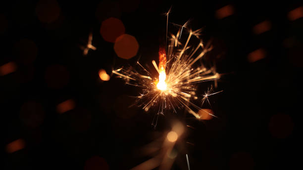 istock festive burning sparkler macro photo multicolor bokeh garlands 1214969270
