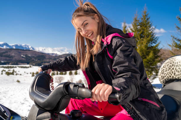 istock Pretty female snowmobile riders in the snow 1214971290