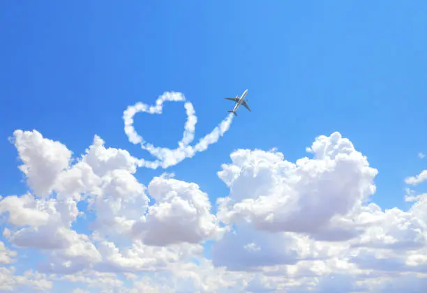 Aircraft draw a heart in the sky. Flight route of aircraft in shape of a heart. Love concept for traveling the world. Copy space for text