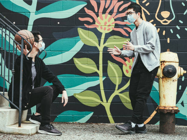 istock COVID-19, Teenagers passing b-ball outside 1214972781
