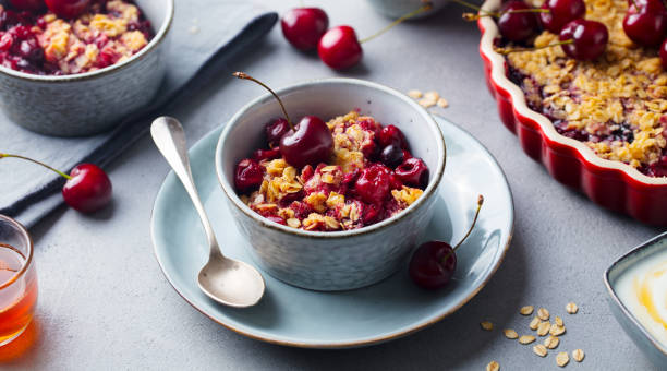istock Healthy breakfast. Cherry, red berry crumble in bowl. Grey background. Close up. 1214976249