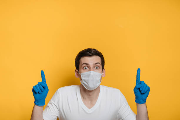 istock Scared of COVID 19 young man pointing to empty space on background 1214977469