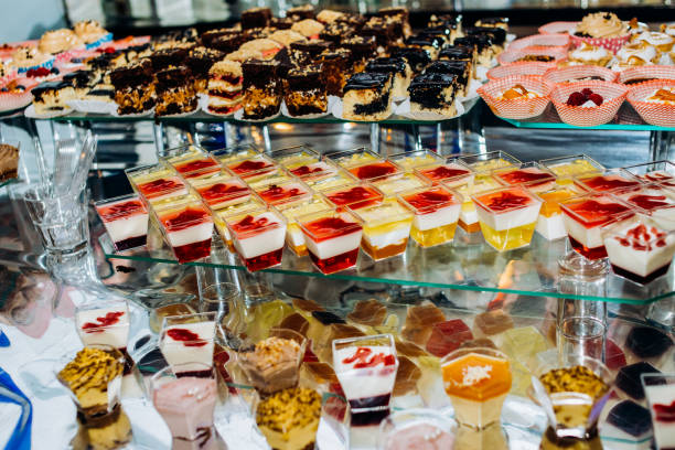 élégant bar à bonbons décorés de luxe pour la célébration d’un mariage de couple heureux, cathering dans le restaurant. table avec des desserts et des bougies. - cathering photos et images de collection