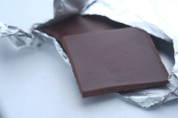 istock Pieces of dark chocolate isolated on white background, close up 1214978785