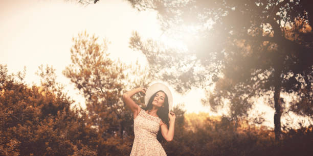 Beautiful woman in hat celebrates spring in the forest