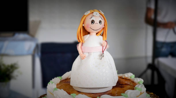 muñeca de comunión sonriente en el pastel - pastel de primera comunión fotografías e imágenes de stock
