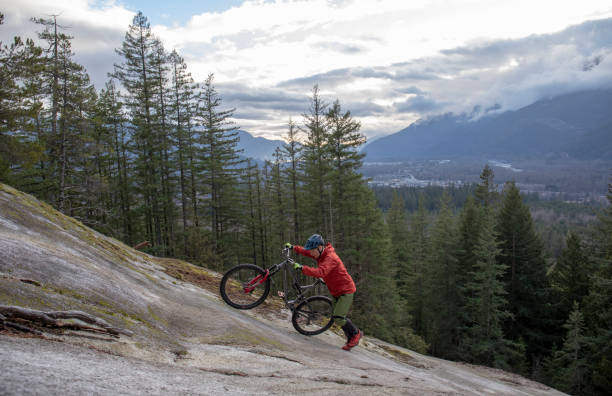 istock Mountain biker pushes bike up rock slabs 1214981079
