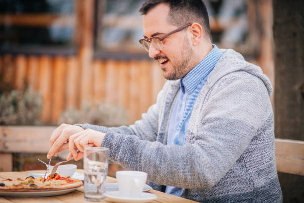 istock handsome man eating pizza at outdoor restaurant 1214981184