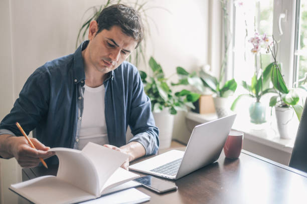 istock Man working from home due to the COVID-19 pandemic 1214982085