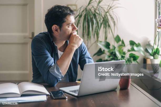 Man Working From Home Due To The Covid19 Pandemic Stock Photo - Download Image Now - Protection, Working At Home, Danger