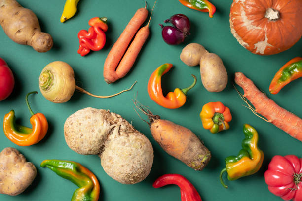 trendy ugly organic vegetables. assortment of fresh eggplant, onion, carrot, zucchini, potatoes, pumpkin, pepper in craft paper bag over green background. top view. cooking ugly food concept. non gmo vegetables - ugliness imagens e fotografias de stock