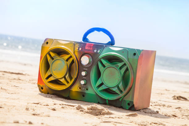 istock Boom box multi coloured in spray paint on beach background 1214985792
