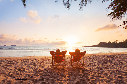 romantic getaway for couple, beach honeymoon travel, silhouettes of man and woman relaxing in hotel