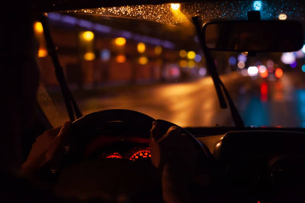 voiture de conduite dans la ville de nuit, mains du conducteur sur le volant - night drive photos et images de collection