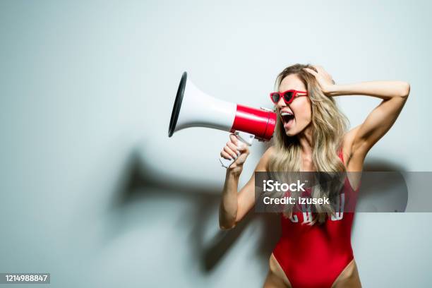 Summer Portrait Of Young Woman Wearing Swimsuit Shouting Into Megaphone Stock Photo - Download Image Now