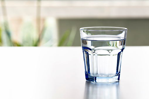 water in a glass on blue background