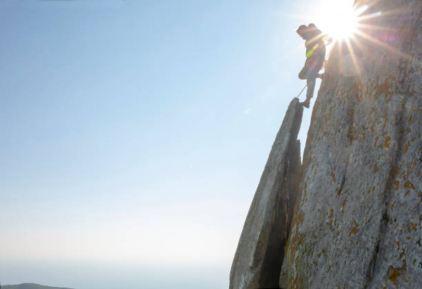 istock Mountain climber ascends rock face at sunrise 1214989698