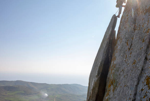 istock Mountain climber ascends rock face at sunrise 1214990264