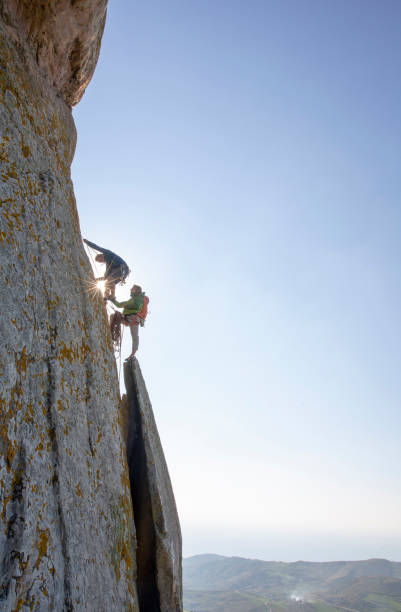 istock Mountain climbers ascend rock face at sunrise 1214990332