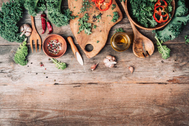 istock Fresh kale in bowl, wooden spoon, fork, chopping board, spices, salt, garlic, pepper on rustic wooden background. Top view. Copy space. Zero waste, organic vegetables concept. Vegan and vegetarian diet food. Healthy food or diet nutrition concept. 1214990377