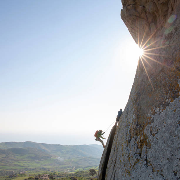 istock Mountain climbers ascend rock face at sunrise 1214990482