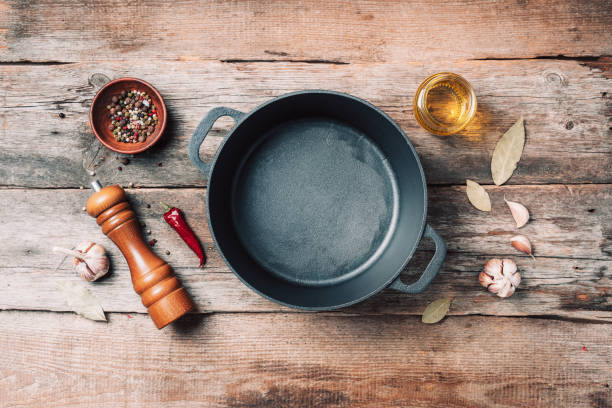 istock Empty iron pot and kitchen utensils on wooden background. Top view. Copy space. Healthy, clean food and eating concept. Zero waste. Cooking frame 1214990707