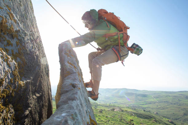 istock Mountain climber ascends rock face at sunrise 1214990712