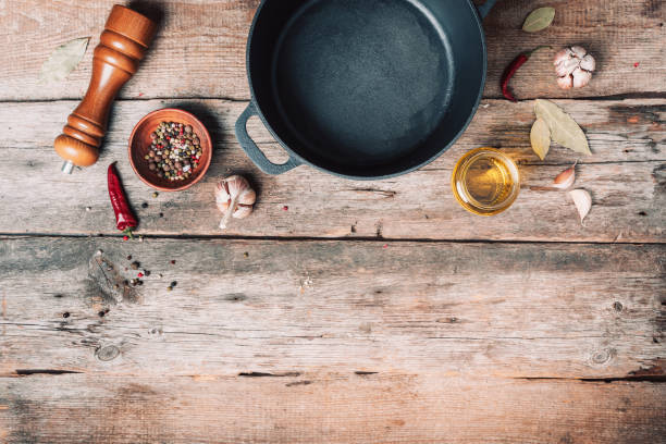 istock Empty iron pot and kitchen utensils on wooden background. Top view. Copy space. Healthy, clean food and eating concept. Zero waste. Cooking frame 1214990732