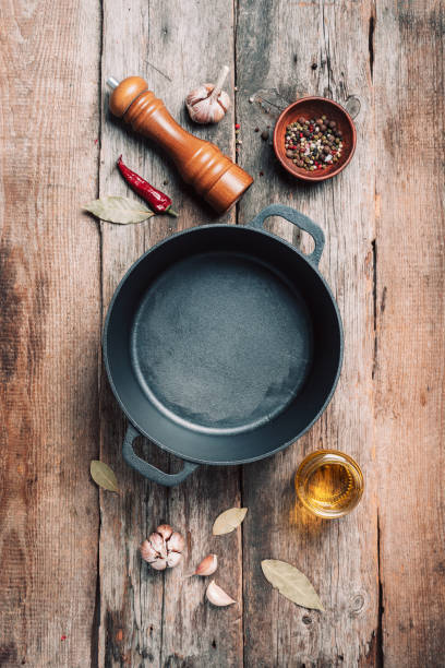 istock Empty iron pot and kitchen utensils on wooden background. Top view. Copy space. Healthy, clean food and eating concept. Zero waste. Cooking frame 1214990737