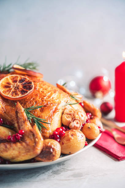 istock Whole roasted chicken with festive decoration, candles, light bokeh on concrete background. Copy space. Friends or family dinner. Festive Christmas table. Traditional Thanksgiving or Friendsgiving holiday celebration dish. 1214991467