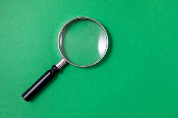 istock Magnifying Glass on Green Background 1214992093