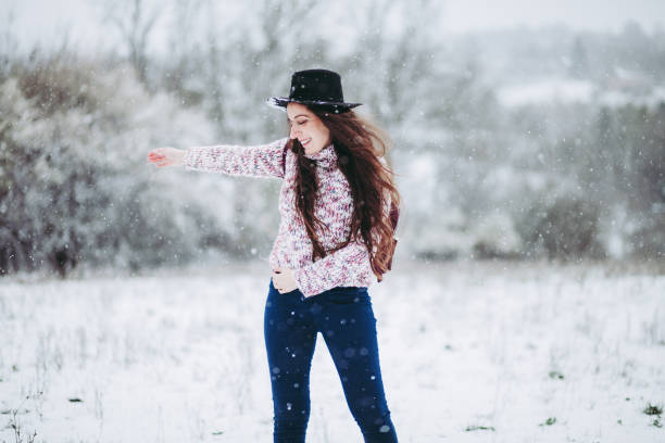 istock Woman with arms outstretched in snow 1214994748