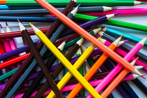 Set of colorful pencils on pink background.
