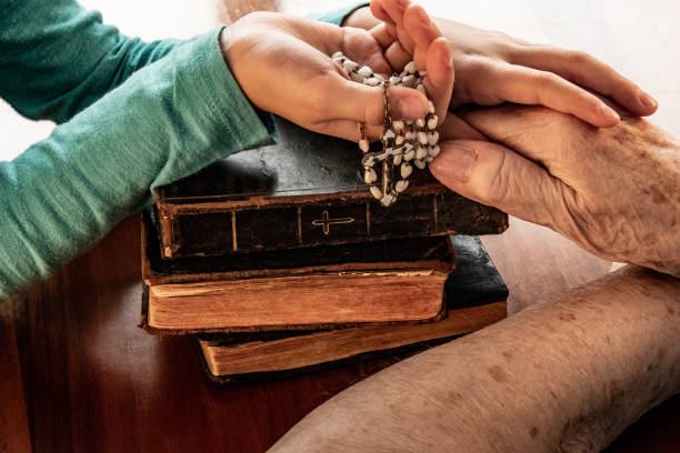 wnuczka modląc się z dziadkiem - rosary beads bible prayer beads catholicism zdjęcia i obrazy z banku zdjęć