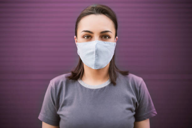 Beautiful girl with medical mask to protect her from virus. Corona virus pandemic stock photo