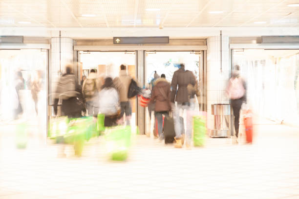 Travellers in blurred motion crowding to get through door at railway station or airport