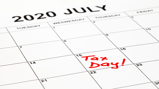 La fecha de vencimiento de los impuestos se fija para el 15 de julio de 2020 debido al brote del virus corona. Página de calendario con el Día de impuestos escrito en rojo, resto para pagar impuestos. El gobierno amplió el llenado y el pago. photo