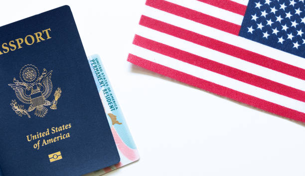American passport with permanent resident card (green card) and United States flag on white background. Citizenship and immigration background concept.  M stock photo