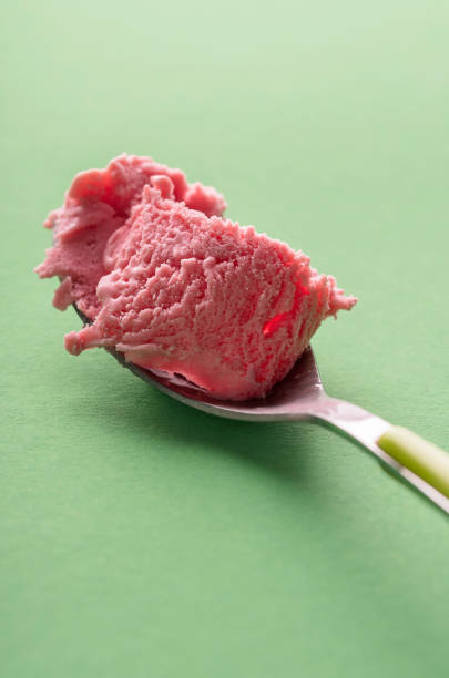 istock Raspberry ice cream spoon close-up. Delicious red berry dessert 1215004389