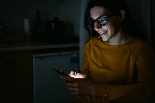 istock Woman using phone in kitchen at night 1215005068