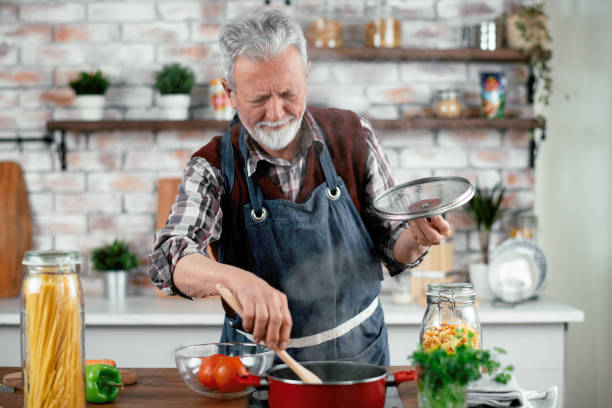 istock Grandfather cooking in kitchen. 1215007164