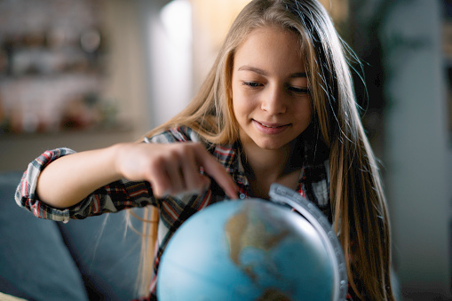 Little girl with globe. Beautiful young girl discovering world.